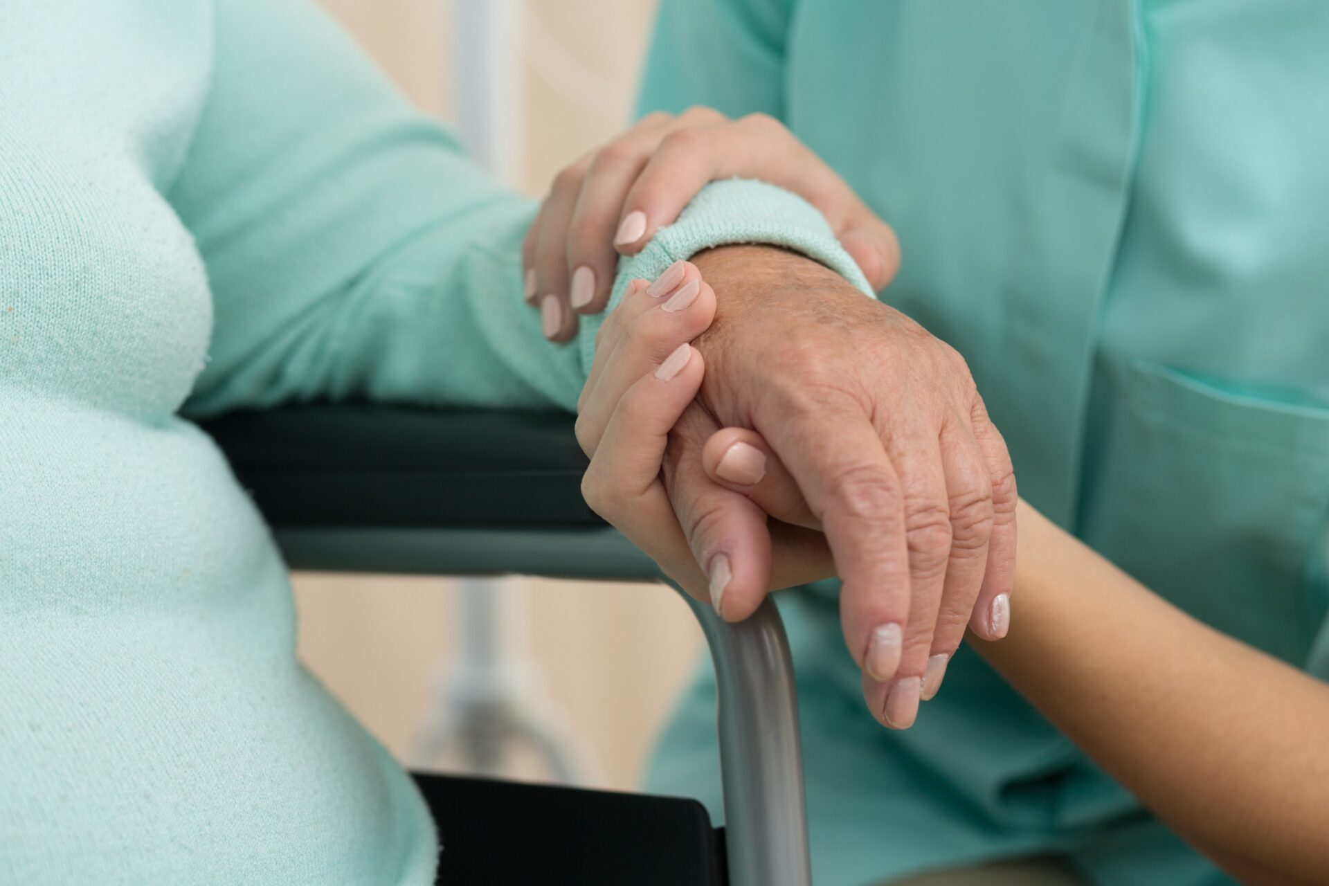 Photo of nurse supporting old woman on wheelchair